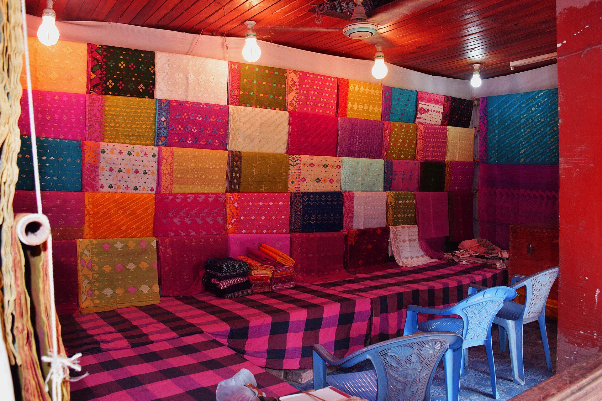 A wall of hand-woven jamdani sarees in a Sonargaon weaver's shop